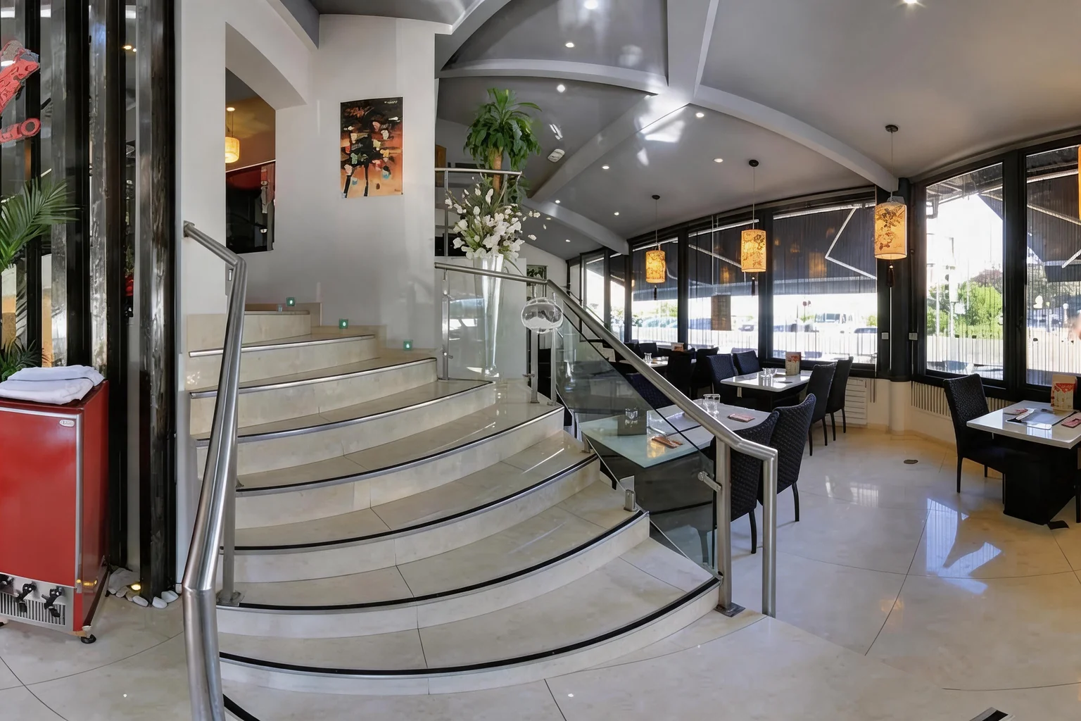 Staircase with light steps and glass-walled dining area